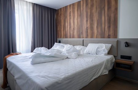 Minimalist Hotel Room Design with Crumpled Sheets and Morning Atmosphereの写真素材
