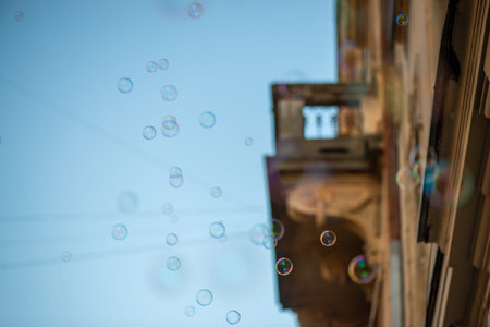 A low angle view of countless soap bubbles creating a playful atmosphere in a historic urban setting