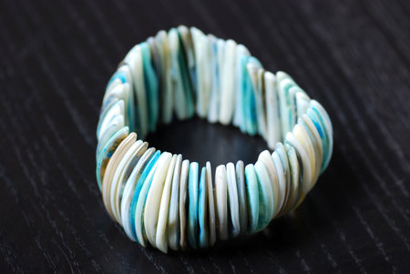 Still life shot of bracelet on black wooden background