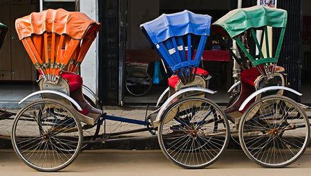The image shows three trishaw's parked side by side.  The trishaw's are predominantly metallic...