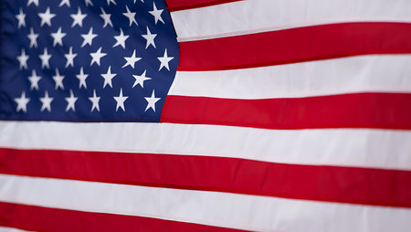 A close-up shot of an American flag, focusing on the detail of the red and white stripes and the...