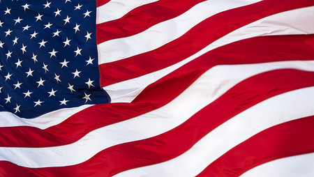 A close-up image of an American flag billowing in the wind. The image showcases the rich red and...