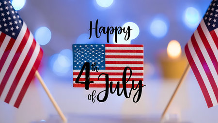Two small American flags are displayed on wooden sticks against a blurred background of blue and yellow bokeh lights.  A central graphic features a stylized American flag with the text "Happy 4th of July" in elegant black script. The flags are slightly out of focus, drawing attention to the central celebratory message. The overall color palette is red, white, and blue, with warm yellow tones in the background blur. The image evokes a feeling of celebration and patriotism.の写真素材