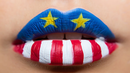 A close-up shot of a person's lips painted in red, white, and blue, resembling the American flag. The upper lip features a blue base with two yellow stars, while the lower lip displays alternating red and white stripes. The paint texture is visible, adding a slightly rough look. The image focuses on the detail and texture of the painted lips, creating a vibrant and bold visual.  The colors are saturated and contrasting, giving a festive mood.の写真素材