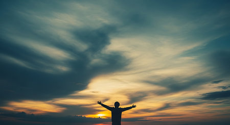 Silhouette of man open arms with sunset sky and cloud backgroundの写真素材