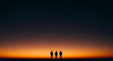 Silhouette of three people on the background of a beautiful sunsetの写真素材
