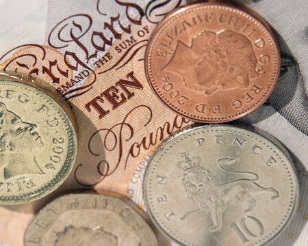 UK coins on ten pound noteの写真素材