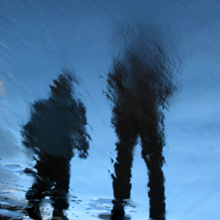 Reflections of two beach walkers