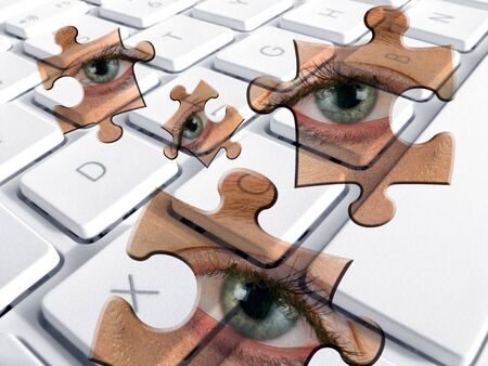 Closeup of laptop keyboard overlaid with jigsaw pieces with eyes.の写真素材