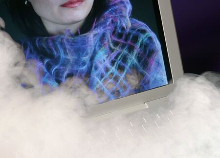 Laptop computer with woman on screen. Overlaid with smoke effect.の写真素材