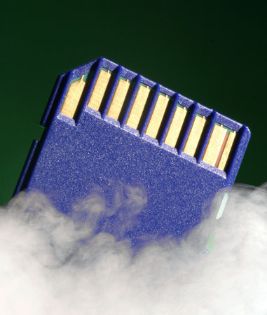 Digital memory card on green background over laid with smoke effect.