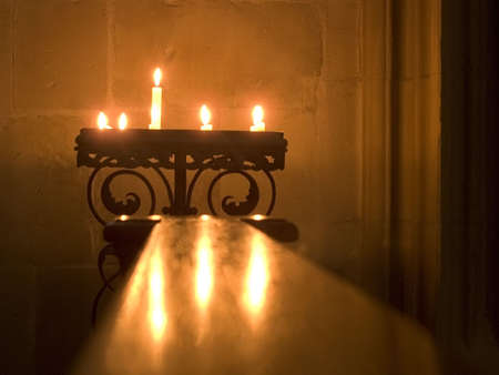 Burning candles light the corner of a church.のeditorial素材