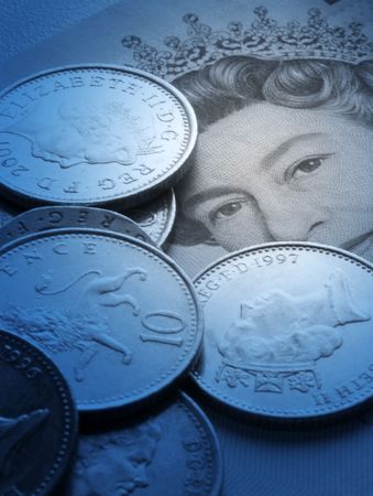 British UK currency note and coins overlaid with blue colour. Spot lighting effect on Queen's eyes on bank noteの写真素材