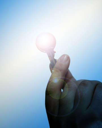 Hand holding key with applied flare lighting effect.の写真素材