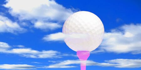 Golf ball on tee against panoramic skyの写真素材