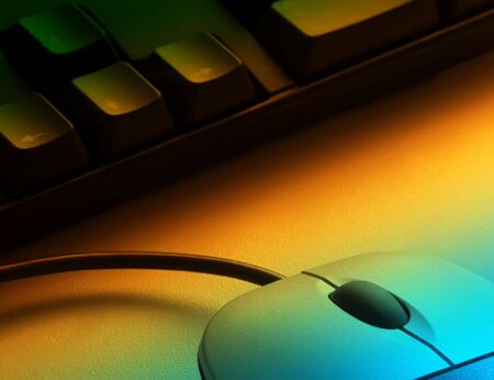 Keyboard and mouse with yellow and blue lighting effectの写真素材