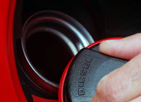 Extreme close-up of male fingers holding fuel capの写真素材
