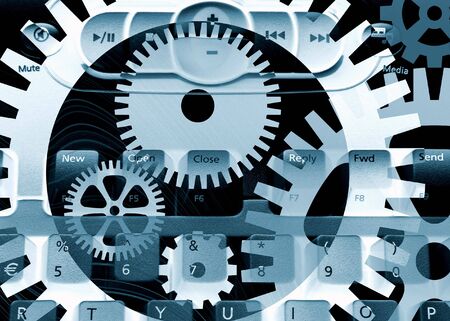 Media computer keyboard overlaid with cogwheel patternの写真素材