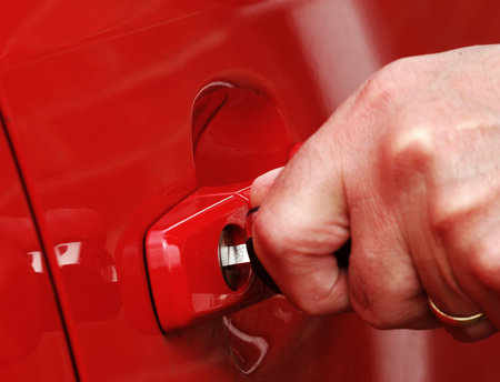 Male hand inserts key into car lockの写真素材