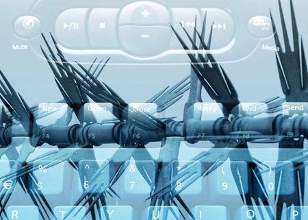 Close-up of computer keyboard overlaid barbed fenceの写真素材