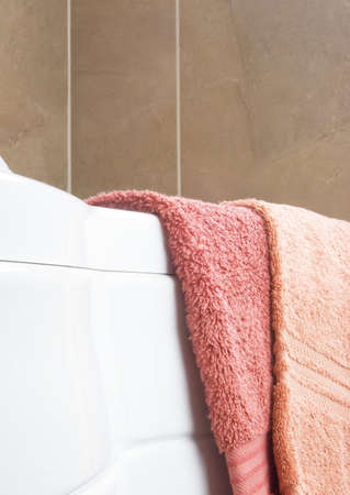 Two towels rest on white bath in modern bathroomの写真素材