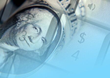 US dollar bank note overlaid over laptop keysの写真素材