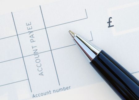 Close-up of pen resting on blank chequeの写真素材