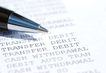 Close-up of ballpoint pen resting on bank statementの写真素材