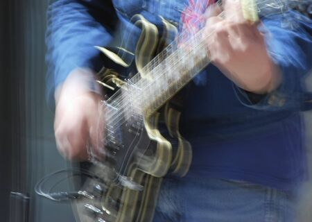 Close-up of male guitar player taken with slow shutter speed for effectの写真素材