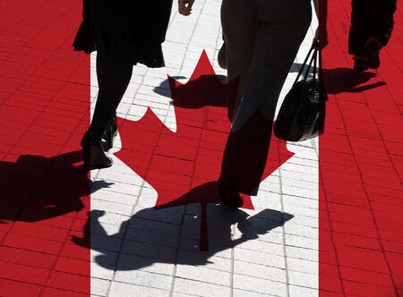 Silhouetted pedestrians overlaid with Canadian flagの写真素材