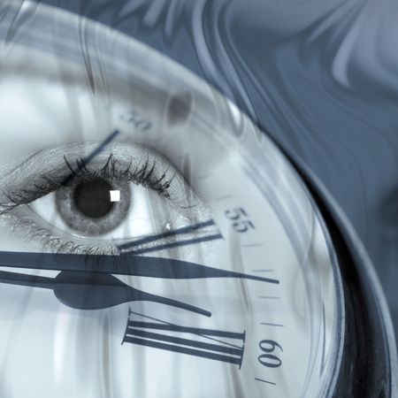Closeup of clock face overlaid with female eyeの写真素材