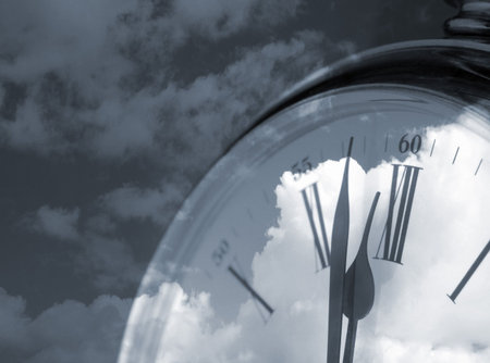 Closeup of clock overlaid with cloud abstract