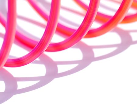 Closeup of colorful toy spring over whiteの写真素材