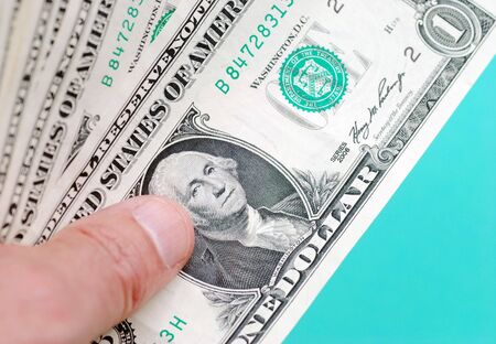 Closeup of hand holding one dollar billsの写真素材