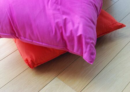 Two luxury cushions rest on laminated wood floorの写真素材