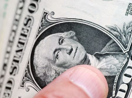 Closeup of fingers holding one dollar billsの写真素材