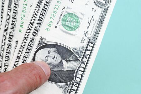 Closeup of hand holding one dollar billsの写真素材