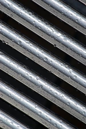 Rain drops cling to stainless steel tubingの写真素材