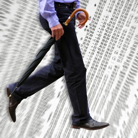 Businessman walks acrross trading figures in newspaperの写真素材