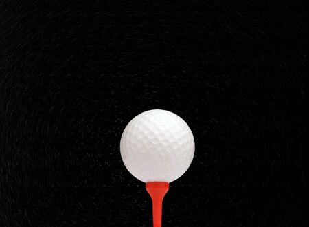 White golf ball on red tee against starry skyの写真素材