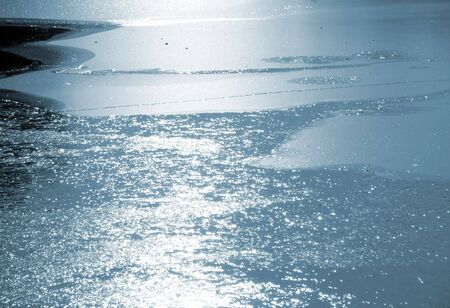 Light reflections from thawing ice on thawing lakeの写真素材