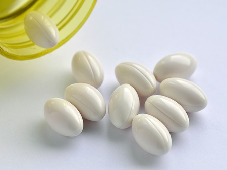 Close up of yellow bottle and white capsulesの写真素材