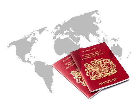 Two British passports over outline map of worldの写真素材