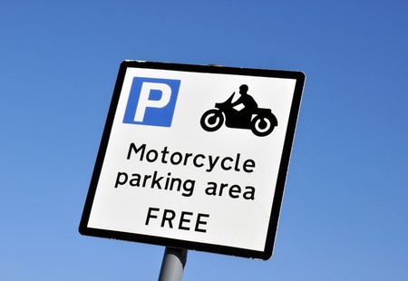 Motorcycle parking area sign against cloudless blue skyの写真素材