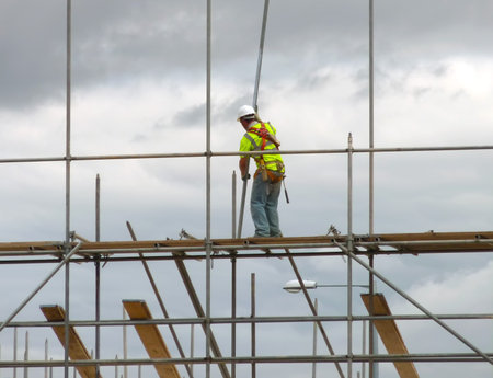 Closeup of construction worker assembling scaffold on building site