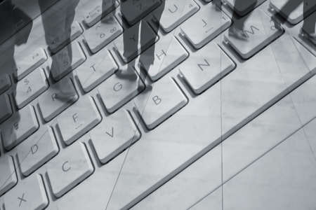 Conceptual image showing shoppers overlaid over laptop keyboard.の写真素材