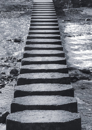 Closeup view of stepping stones crossing riverの写真素材