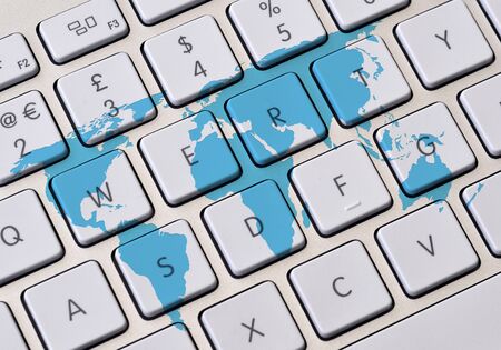 Computer keyboard overlaid with outline world map.の写真素材