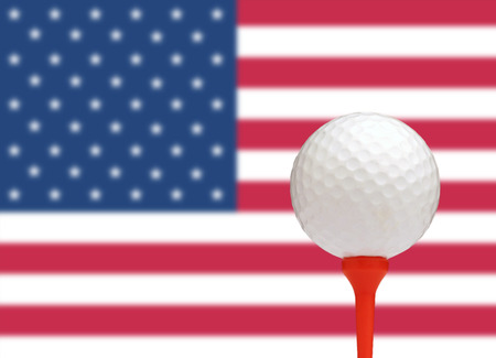 Golf ball on tee in front of the flag of the United States of Americaの写真素材