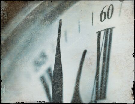Grunge effect applied to clockface with minute hand approaching the twelve position.の写真素材